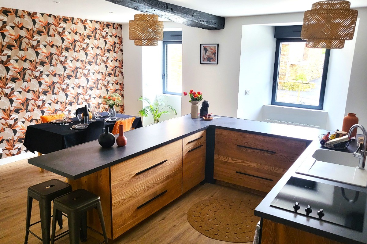 Pièce de vie au rez-de-chaussée avec sa cuisine ouverte, un coin séjour, un coin salon. 2 escaliers de part et d'autres desservent les 2 chambres.