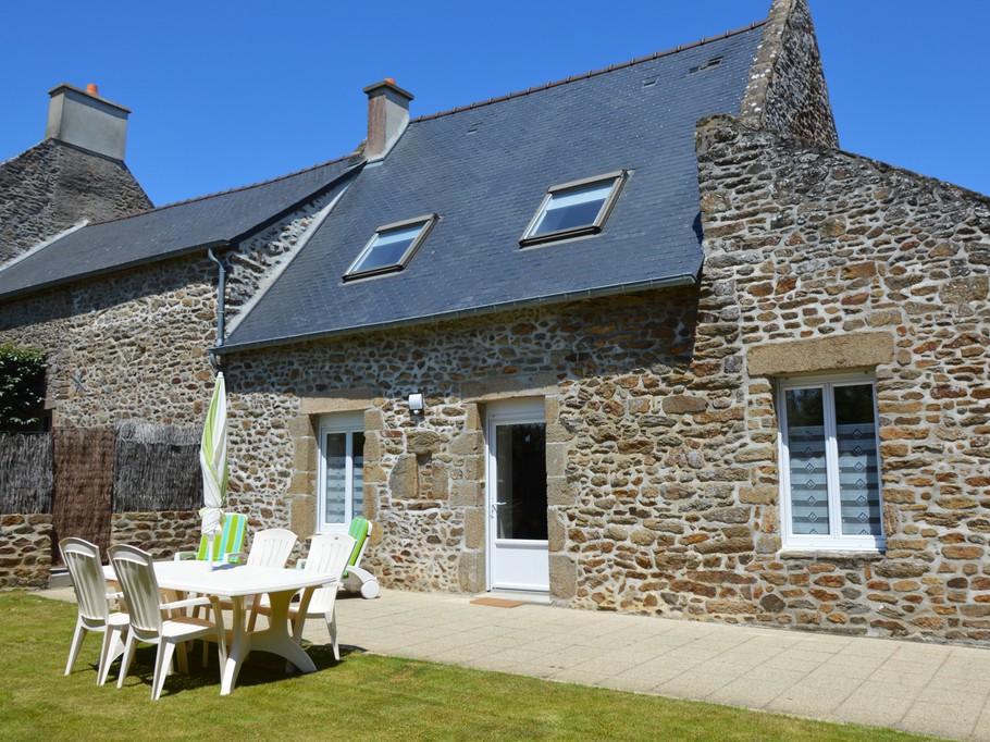 Façade en pierre du Gîte 2 avec terrasse, jardin, balançoire, bac à sable et stationnements privatifs. Accès indépendant.