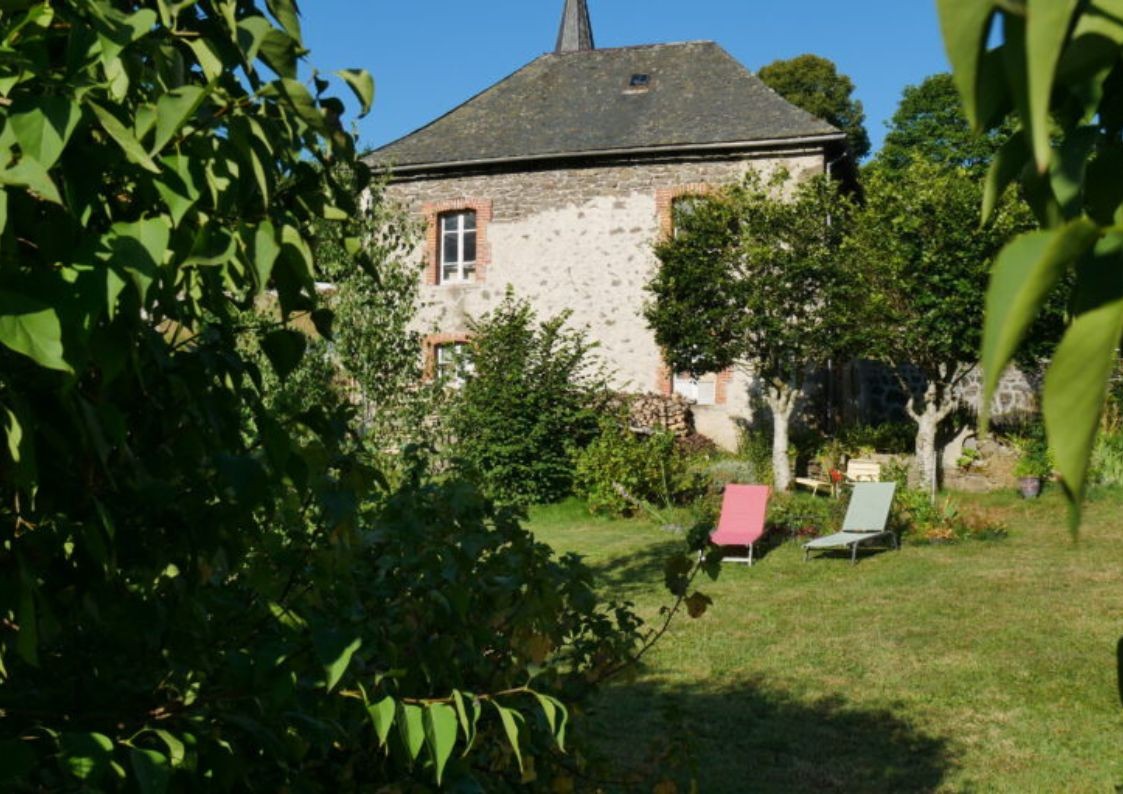 Garden and stone façade of the gîte at Le Claux in the Cantal
