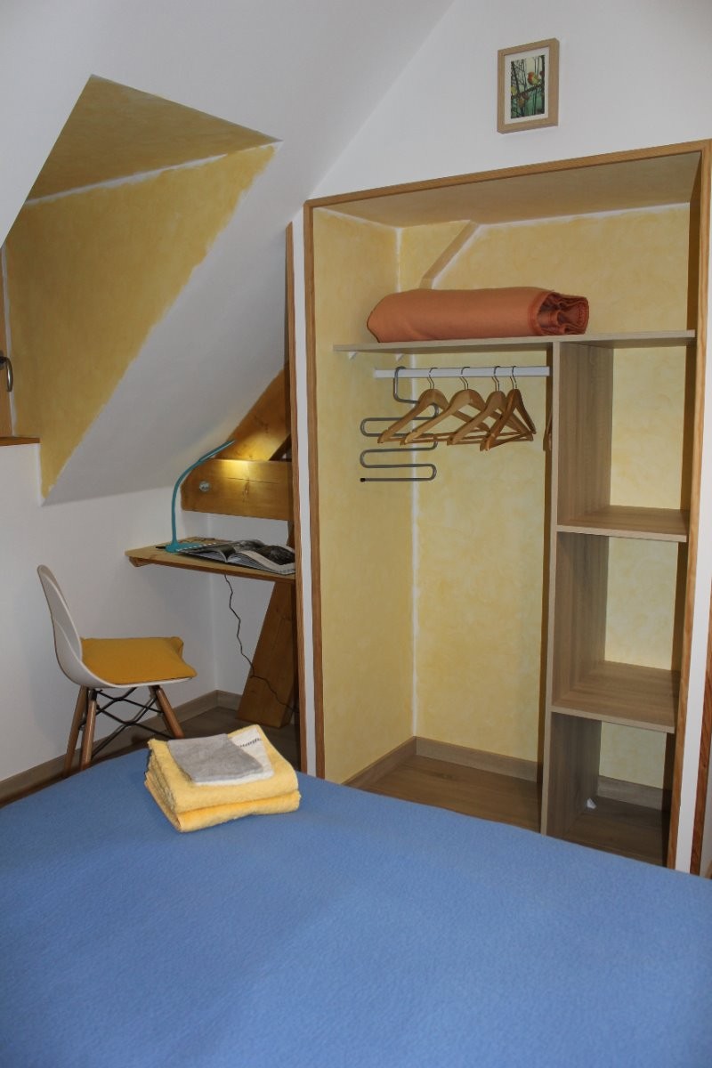 La chambre jaune avec le rangement et un petit bureau