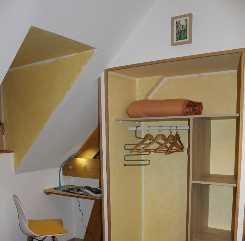 La chambre jaune avec le rangement et un petit bureau