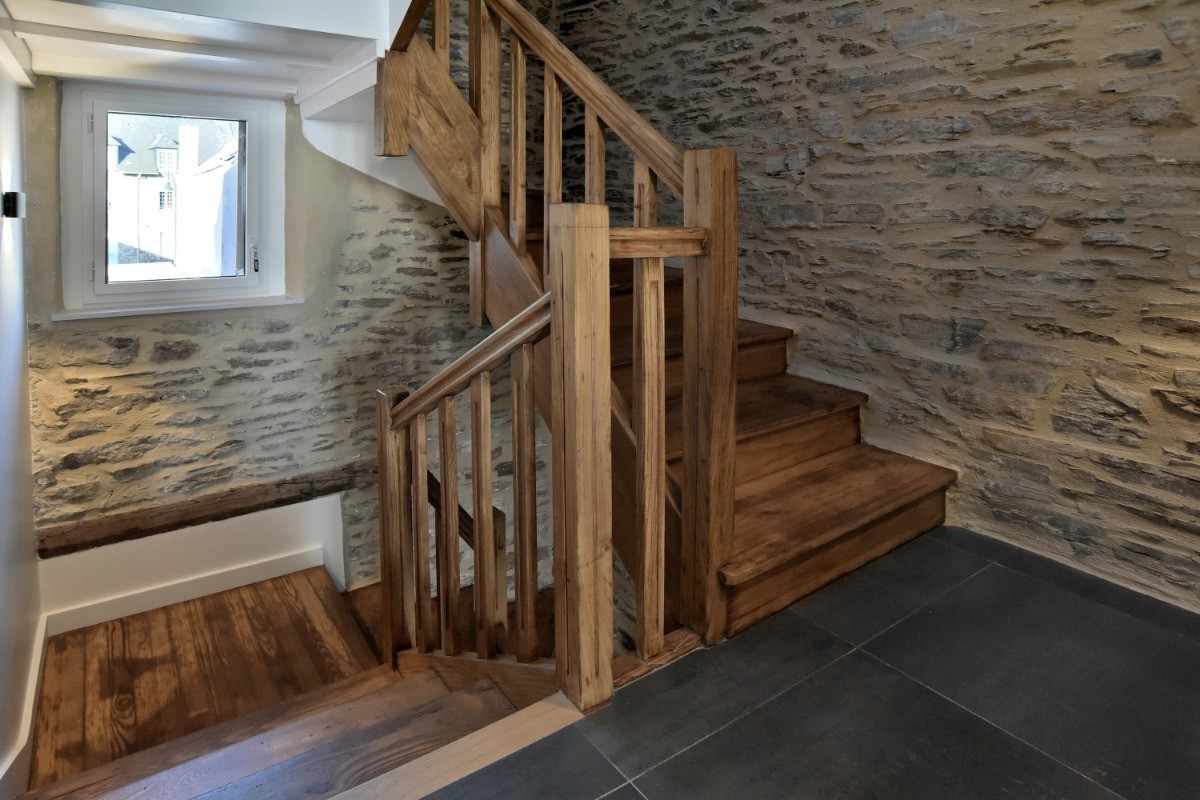 Escalier commun menant au 1er et au 2nd étage. La bâtisse a été complètement rénovée, tout en conservant les pierres de pays.