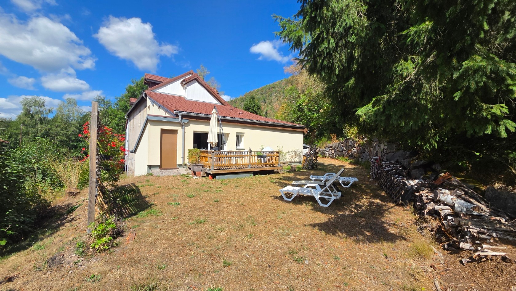 Terrasse équipée d'un barbecue, d'un salon de jardin.