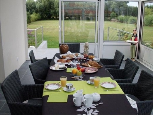 petit déjeuner dans la véranda avec vue sur le jardin et les pics-vert
