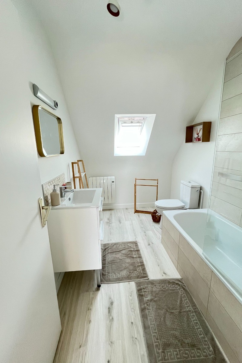 A l'étage, salle de bain grande dimension avec meuble vasque et WC.