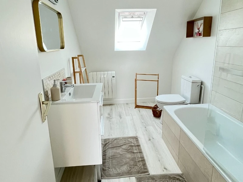 A l'étage, salle de bain grande dimension avec meuble vasque et WC.
