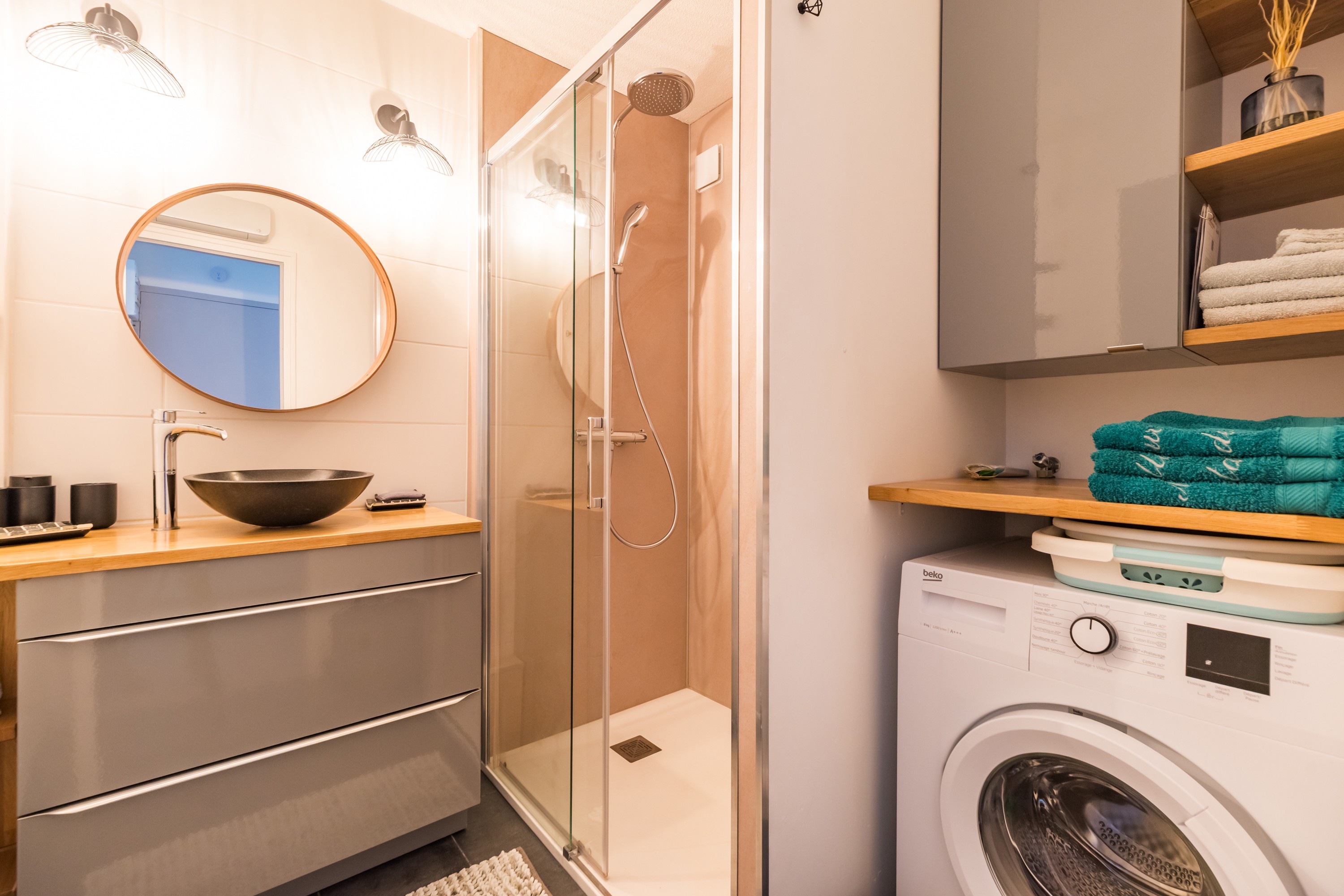 shower room with spacious walk-in shower, washing machine and storage space