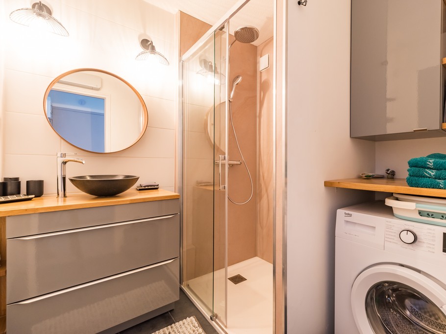 shower room with spacious walk-in shower, washing machine and storage space