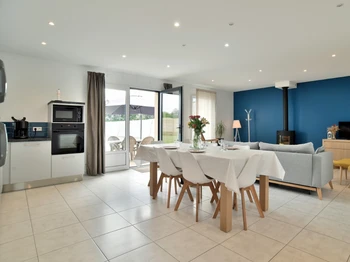 Grande pièce de vie avec coin cuisine, coin séjour et coin salon avec poêle à bois. Cuisine ouverte, aménagée et toute équipée.