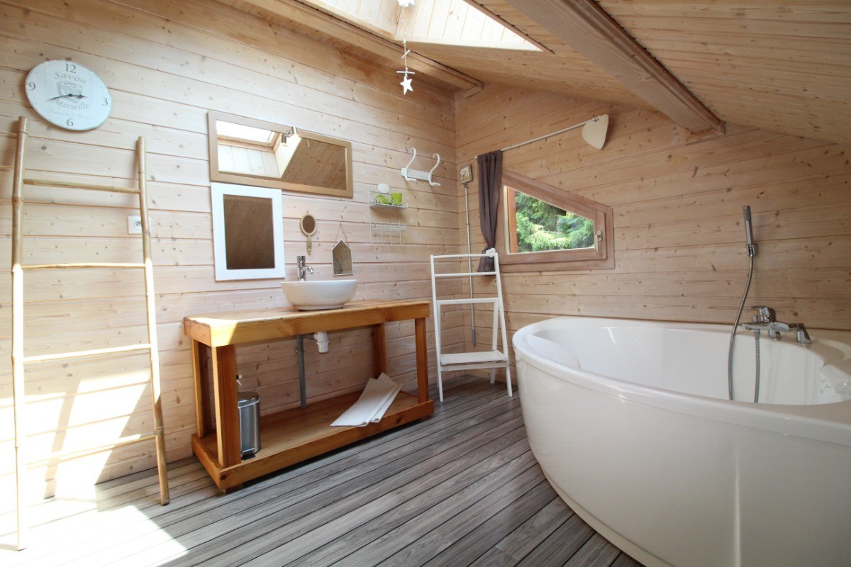 Salle de bain avec baignoire, toilettes et matériel de puériculture mis à disposition.