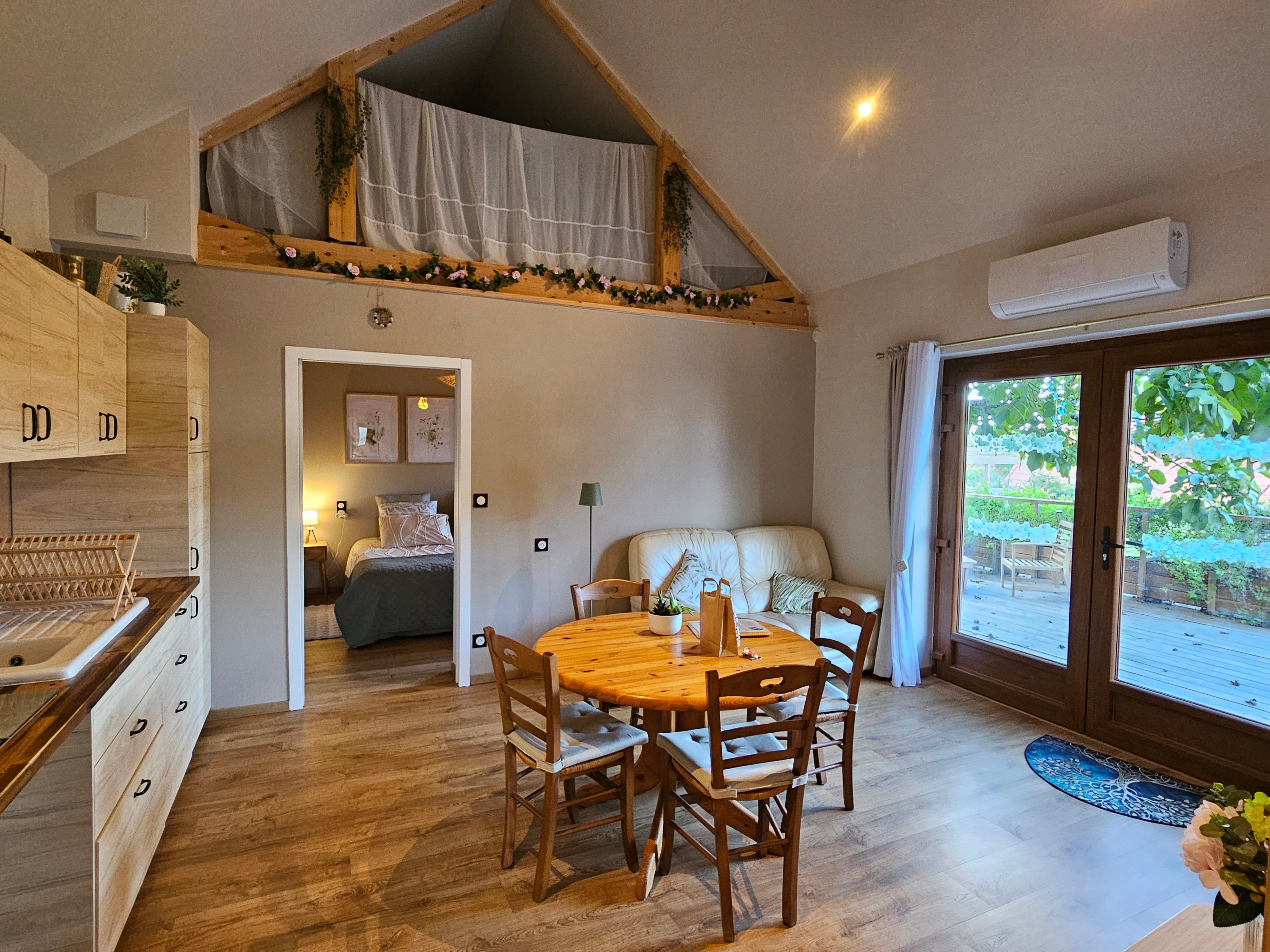 Open-plan living area with a fitted kitchen, lounge and dining table.