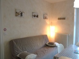 Coin salon (canapé convertible) dans la pièce de vie, avec accès direct à la terrasse privative.