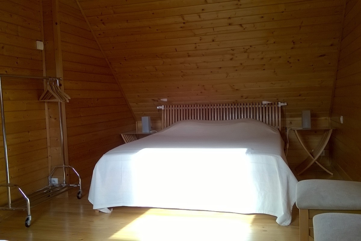 Une des chambre de l'étage avec son grand lit double et un lit simple