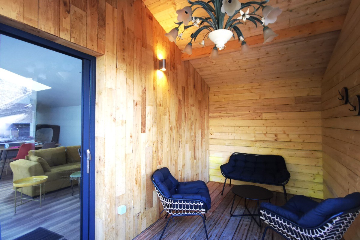 Terrasse extérieure couverte. Grande terrasse de plus de 40 mètres carrés avec transats et salon de jardin.