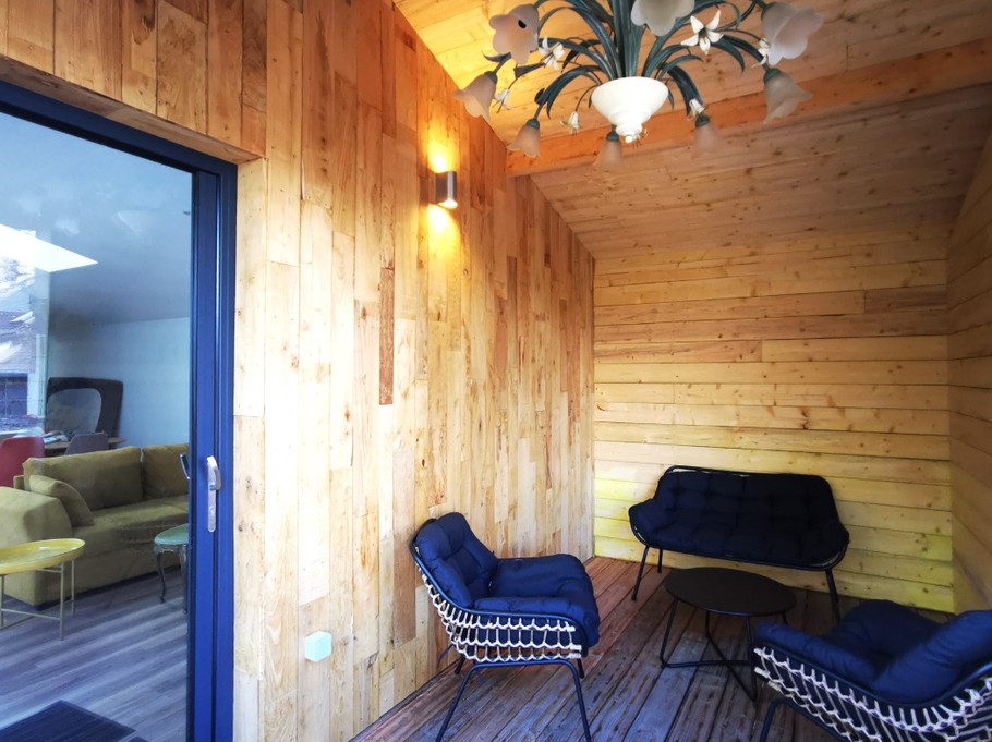 Terrasse extérieure couverte. Grande terrasse de plus de 40 mètres carrés avec transats et salon de jardin.