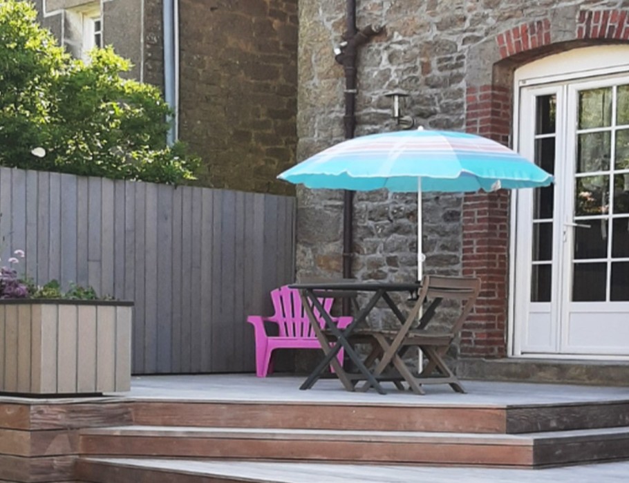 La terrasse en bois privative avec son salon de jardin. Des brises vue sont prévus pour 2024 pour plus d'intimité. Barbecue commun à disposition.