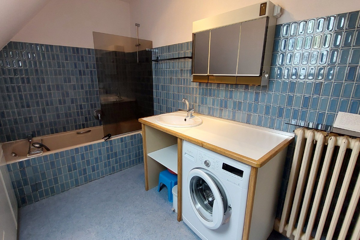 La salle de bain avec machine à laver