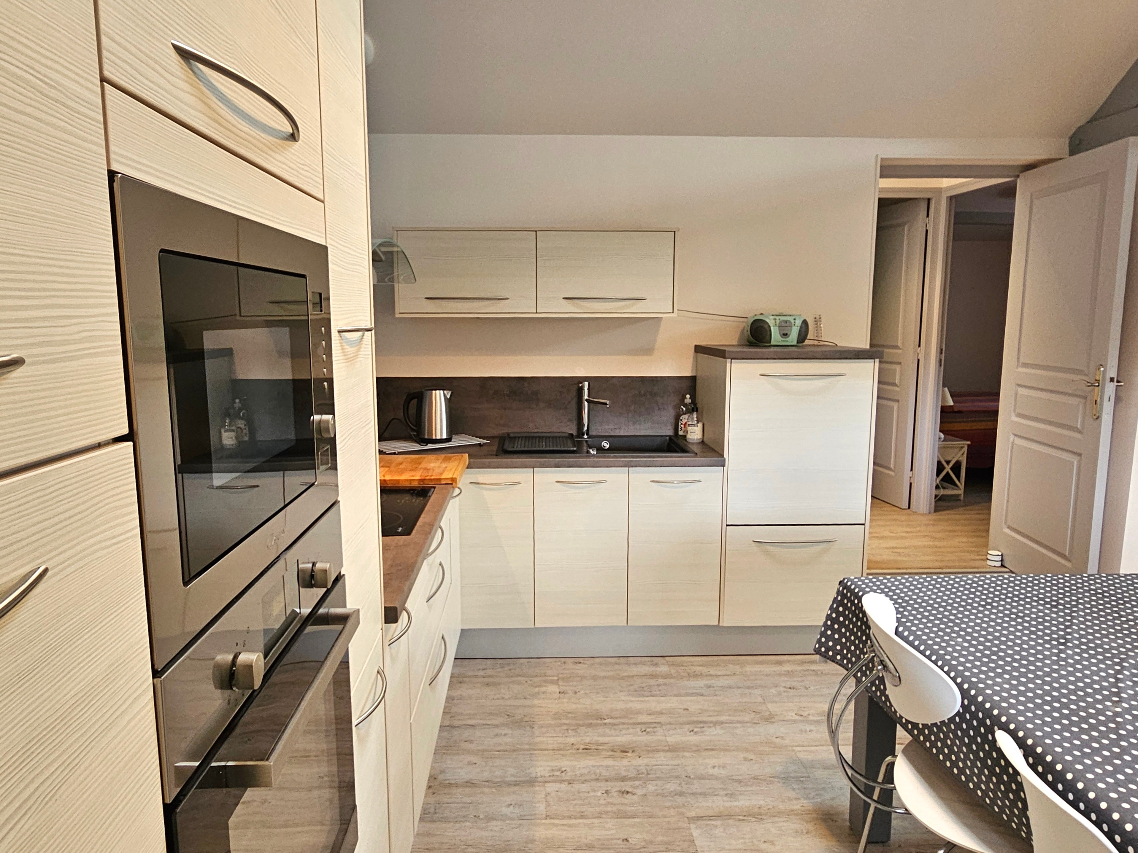 Living room with fitted kitchen, lounge and sitting area. Access to private terrace.