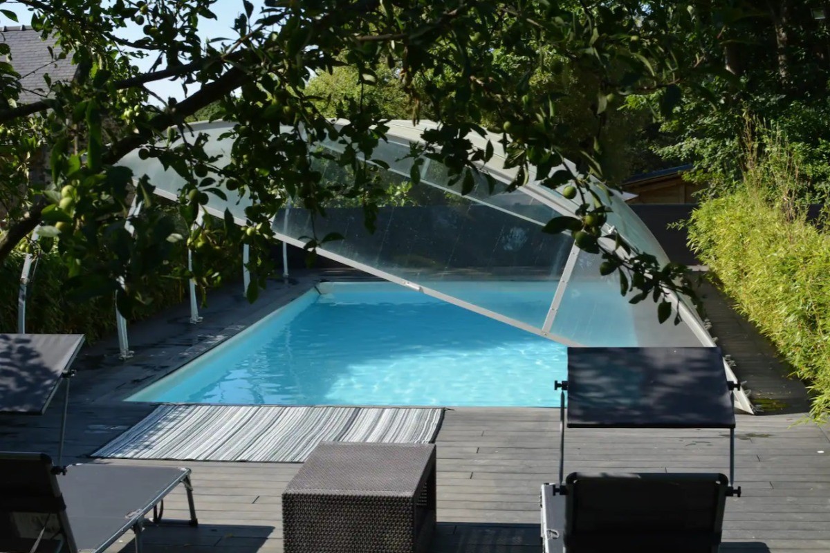 Piscine chauffée extérieure commune avec transat salon de jardin