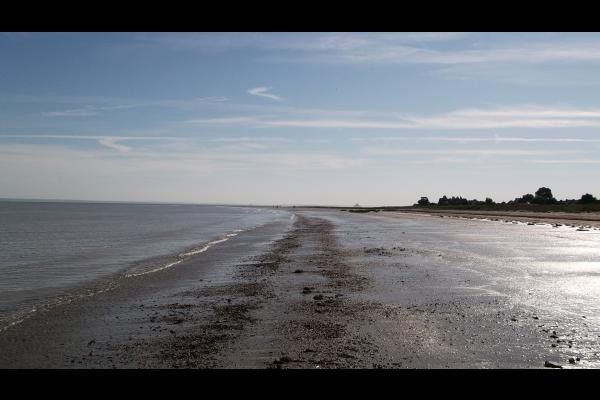 Vue sur le Mont-Saint-Michel et la digue depuis la grève