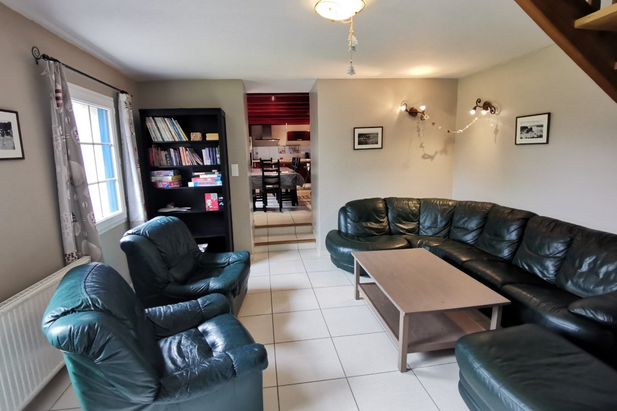 Salon avec TV et coin bibliothèque
