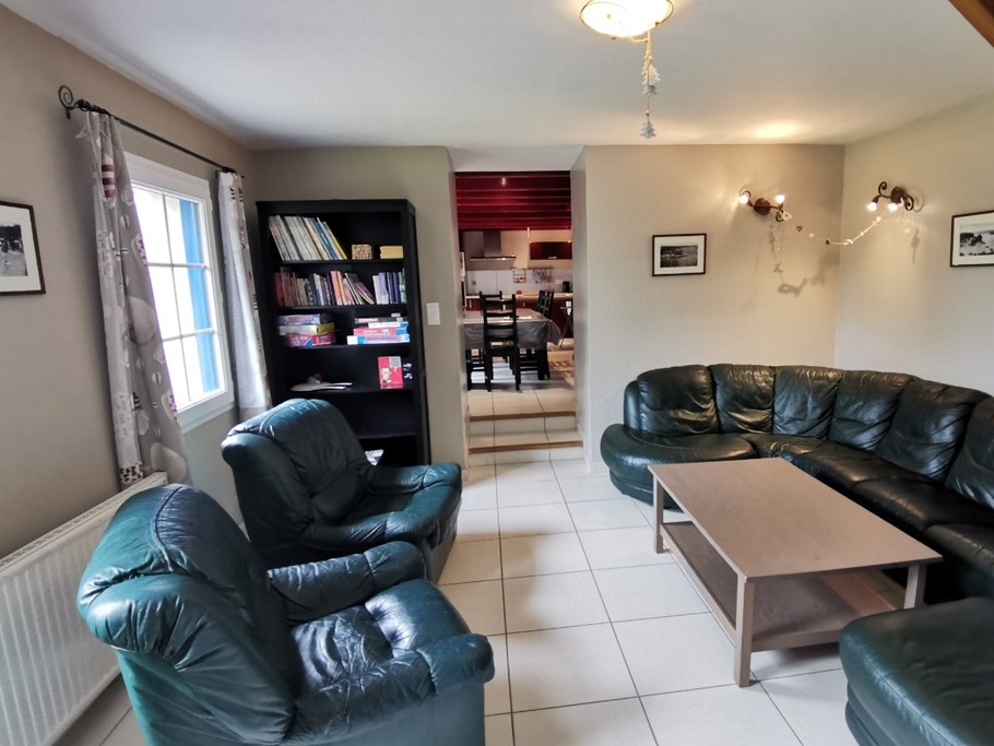 Salon avec TV et coin bibliothèque