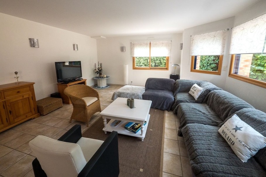 Grande pièce de vie lumineuse avec accès jardin. Coin salon.