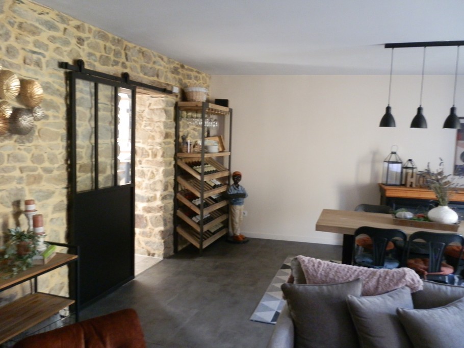 Pièce à vivre commune avec espace salon (TV, bibliothèque, chaine hifi), cheminée en hiver, espace petit-déjeuner.