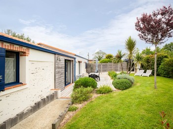 Jardin privatif avec terrasse, salon de jardin, transats, parasol, barbecue et fils à linge.