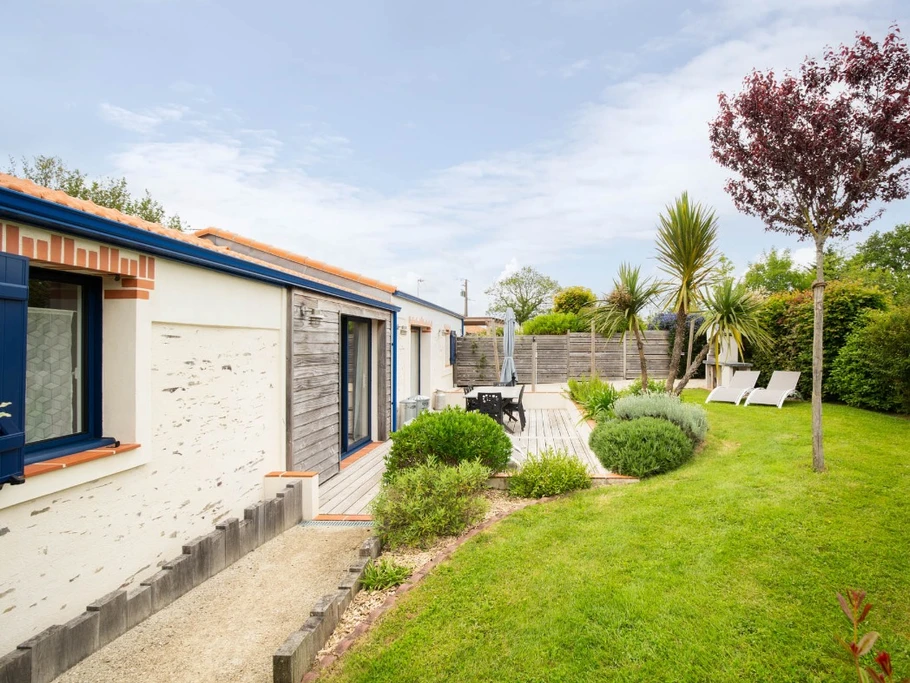 Jardin privatif avec terrasse, salon de jardin, transats, parasol, barbecue et fils à linge.