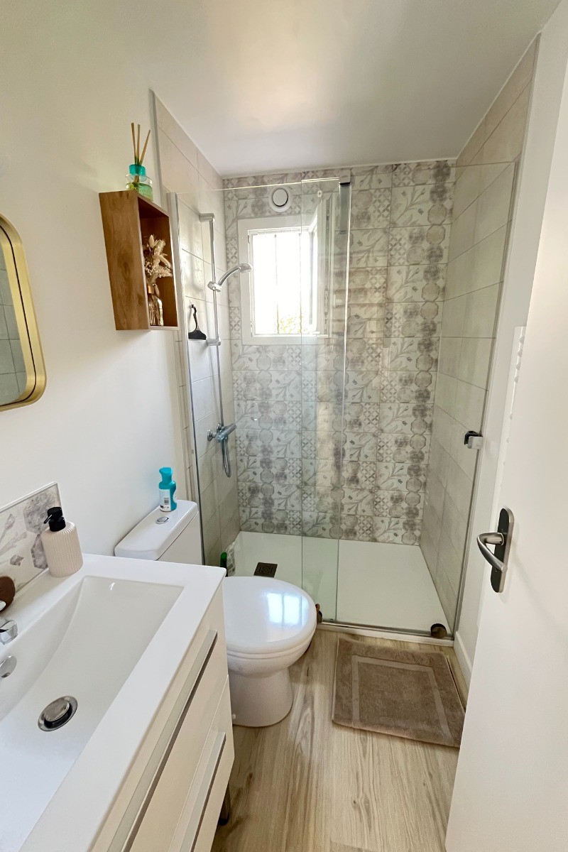 Au rez-de-chaussée, salle d'eau avec une douche grande dimension, meuble vasque et WC.