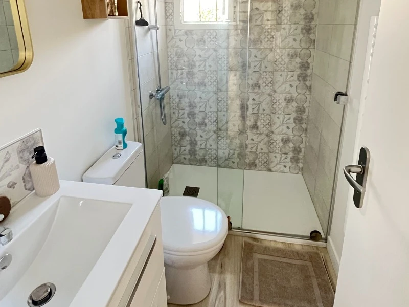 Au rez-de-chaussée, salle d'eau avec une douche grande dimension, meuble vasque et WC.