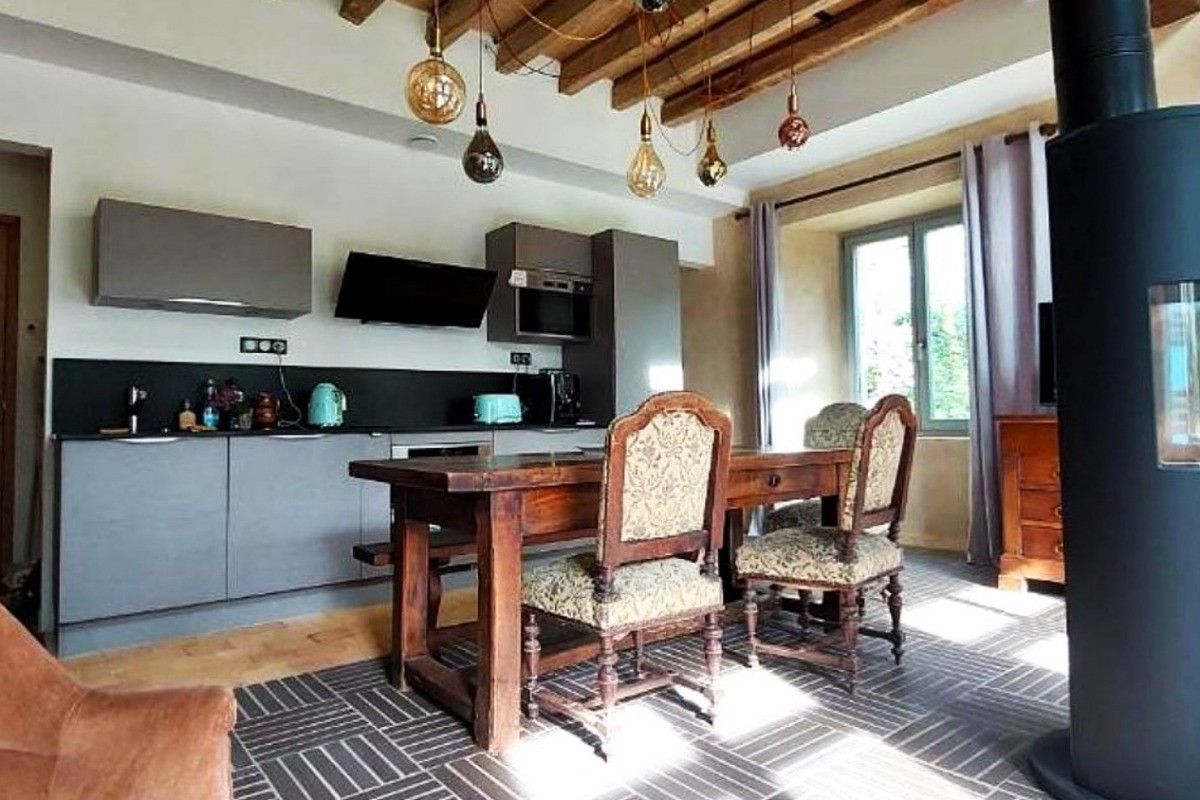 Pièce de vie en rez-de-jardin équipée d'un poêle à bois, avec espace salon, espace séjour et espace cuisine parfaitement équipée. Vaisselle haut de gamme fabriquée en France et électroménager de très bonne qualité.