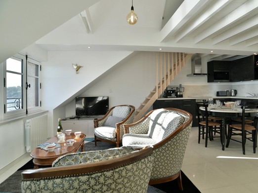 Pièce de vie très lumineuse vue mer panoramique. Mezzanine à l'étage avec deux couchages, conseillée pour les enfants (faible hauteur sous plafond).
Appartement au 2nd étage en front de mer au Port de la Houle à Cancale.