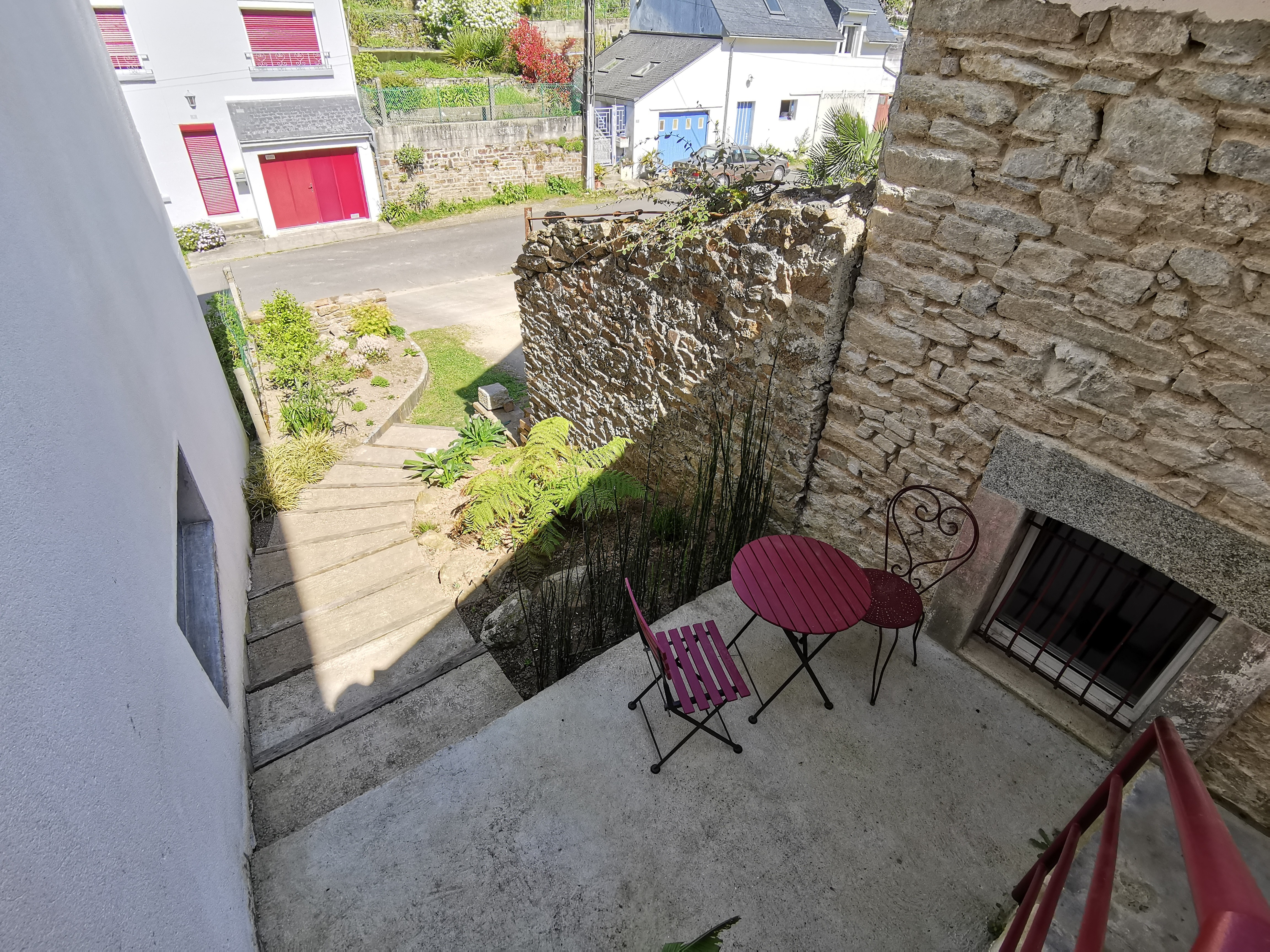 Petite terrasse avec table de jardin donnant à l'arrière de l'appartement