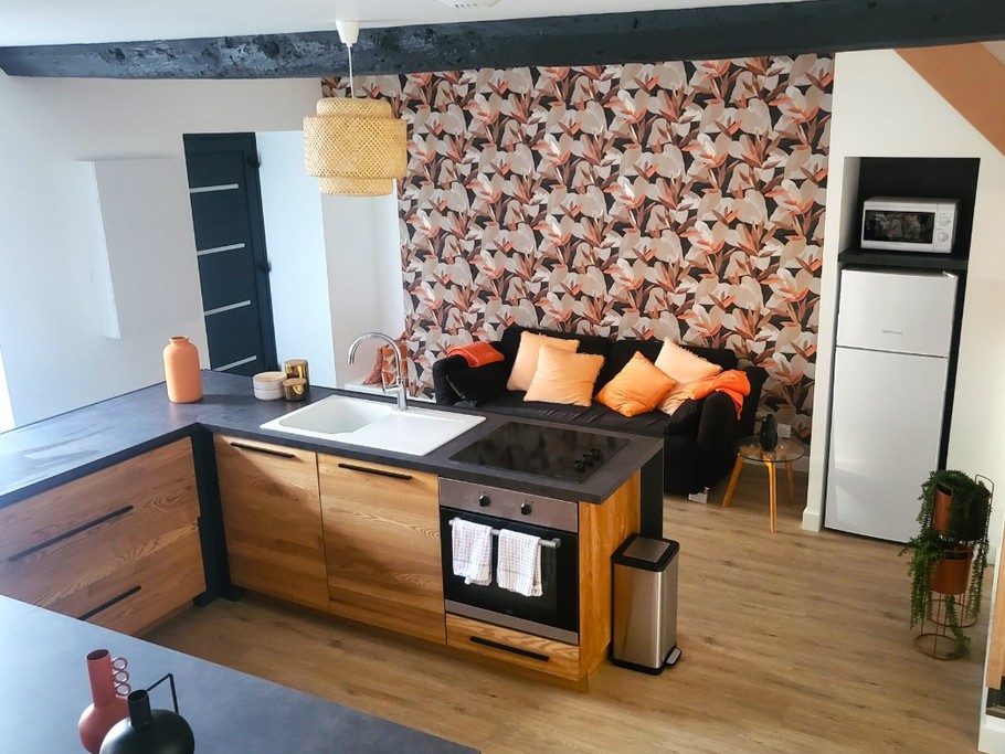 Pièce de vie au rez-de-chaussée avec sa cuisine ouverte, un coin séjour, un coin salon. 2 escaliers de part et d'autres desservent les 2 chambres.