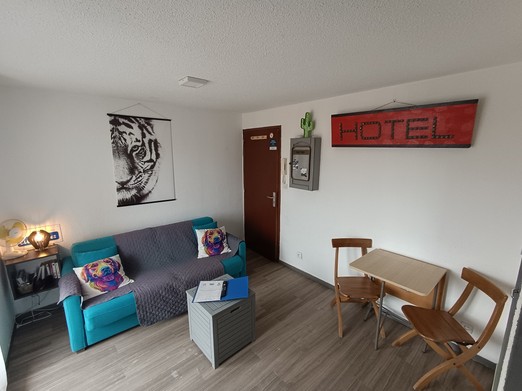 Pièce de vie avec canapé lit et coin repas