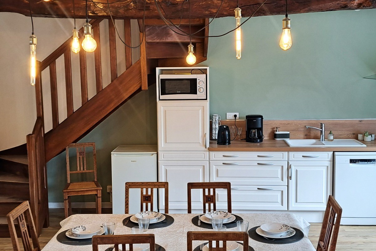 Grande pièce de vie au rez-de-chaussée avec espace cuisine ouverte, séjour et salon. Accès direct à la terrasse et au jardin clos par la baie vitrée.