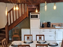 Grande pièce de vie au rez-de-chaussée avec espace cuisine ouverte, séjour et salon. Accès direct à la terrasse et au jardin clos par la baie vitrée.