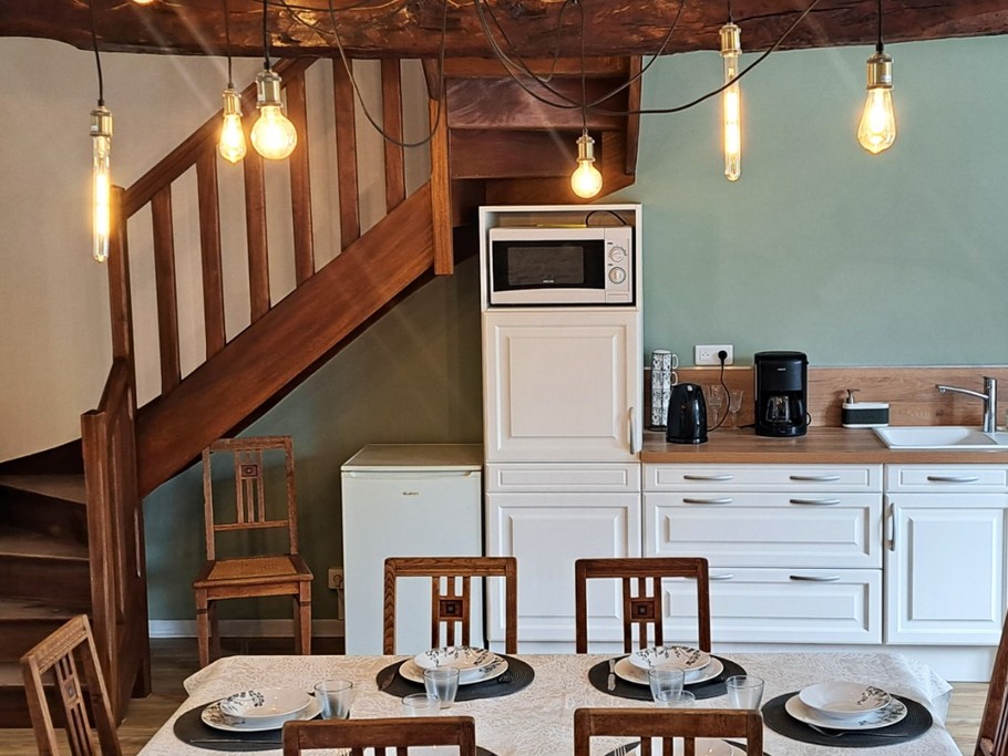 Grande pièce de vie au rez-de-chaussée avec espace cuisine ouverte, séjour et salon. Accès direct à la terrasse et au jardin clos par la baie vitrée.