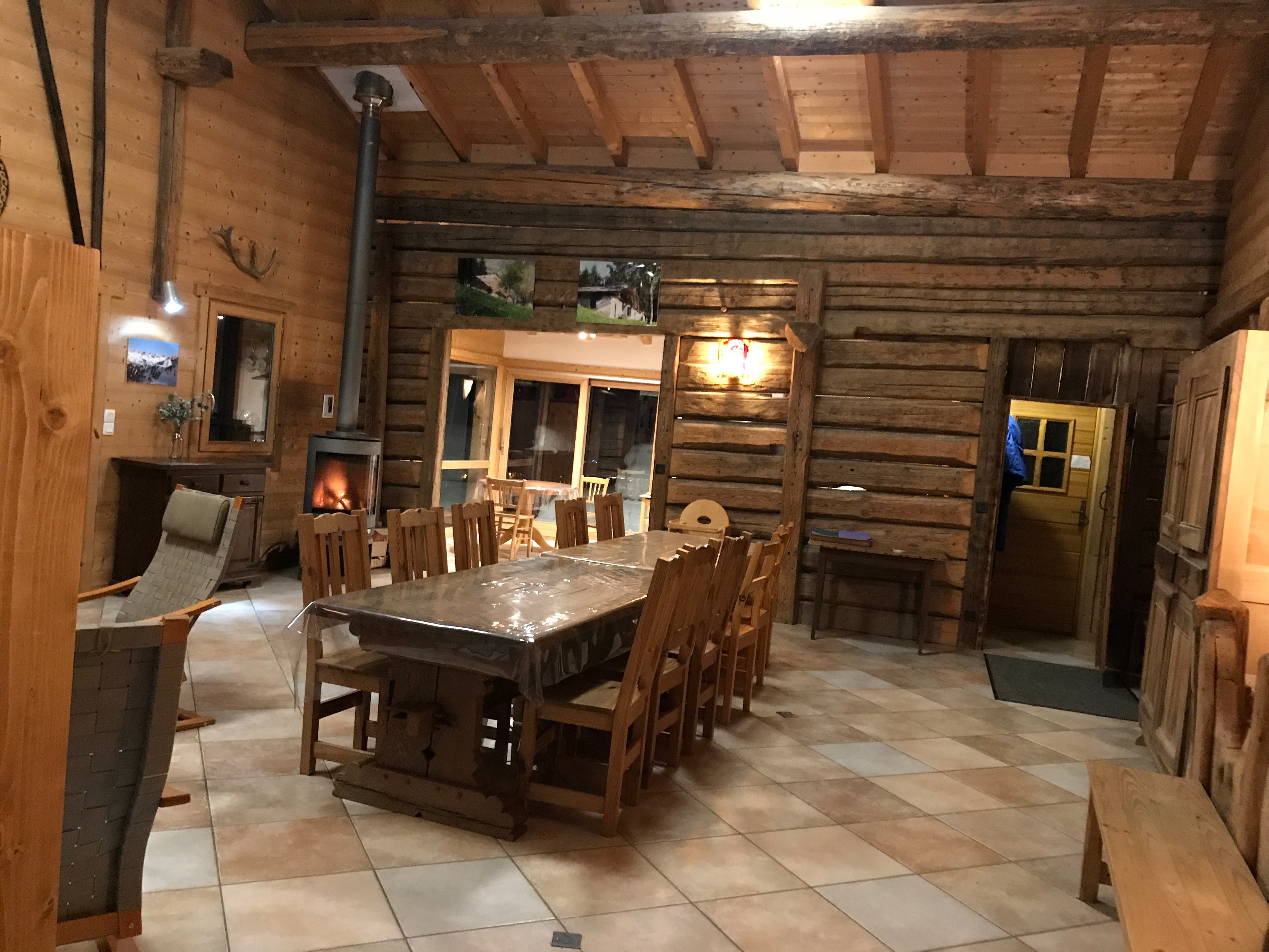 Grande pièce à vivre, vue vers la cuisine ouverte et le poêle à bois convivial