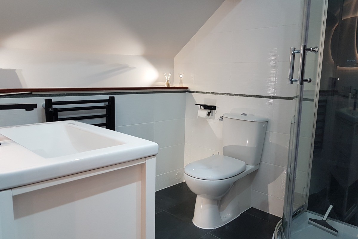 Salle d'eau attenante à la suite parentale avec douche balnéo et WC.