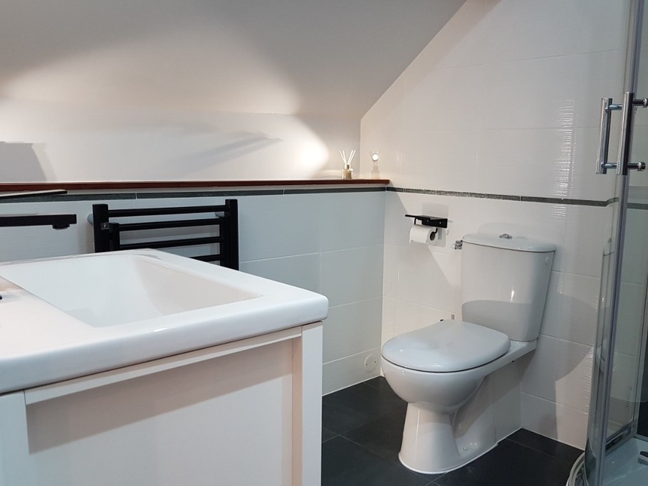 Salle d'eau attenante à la suite parentale avec douche balnéo et WC.