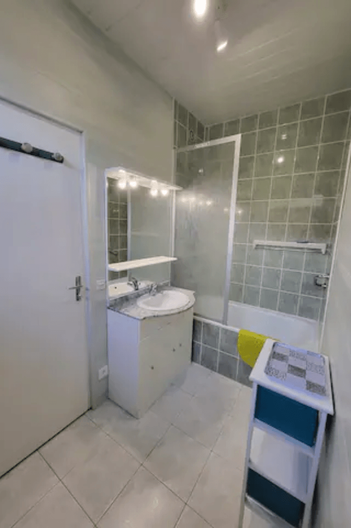 Salle de bain avec baignoire pare-douche ,vasque et WC et sèche-cheveux
