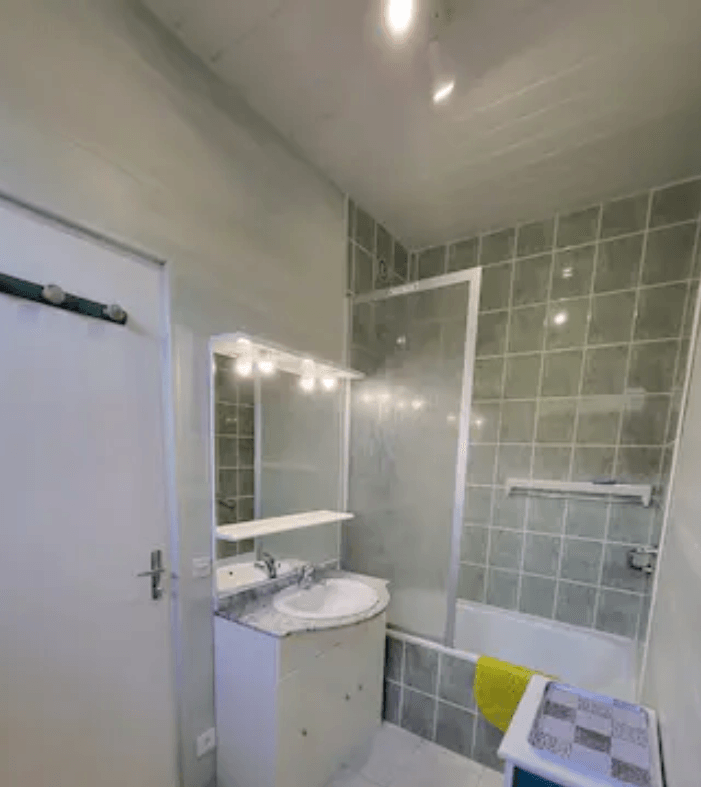 Salle de bain avec baignoire pare-douche ,vasque et WC et sèche-cheveux