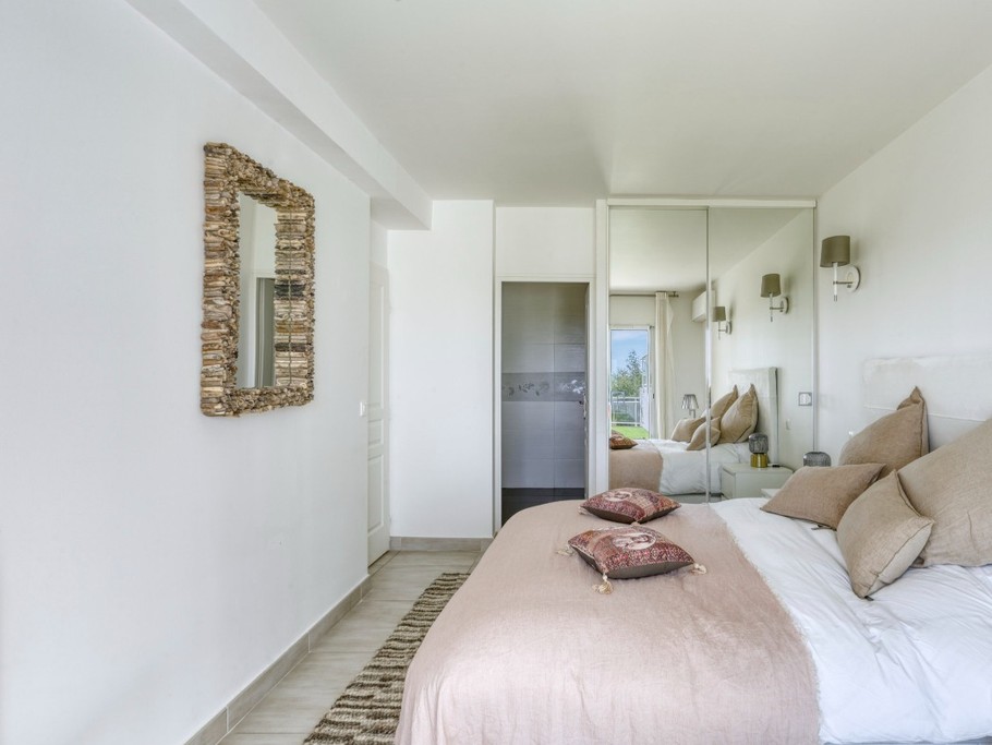 Chambre matrimoniale au RDC (lit 160x200) avec placards de rangement communiquant sur une salle de bain avec douche. Climatisation (chaud/froid) et stores électriques obscurcissants