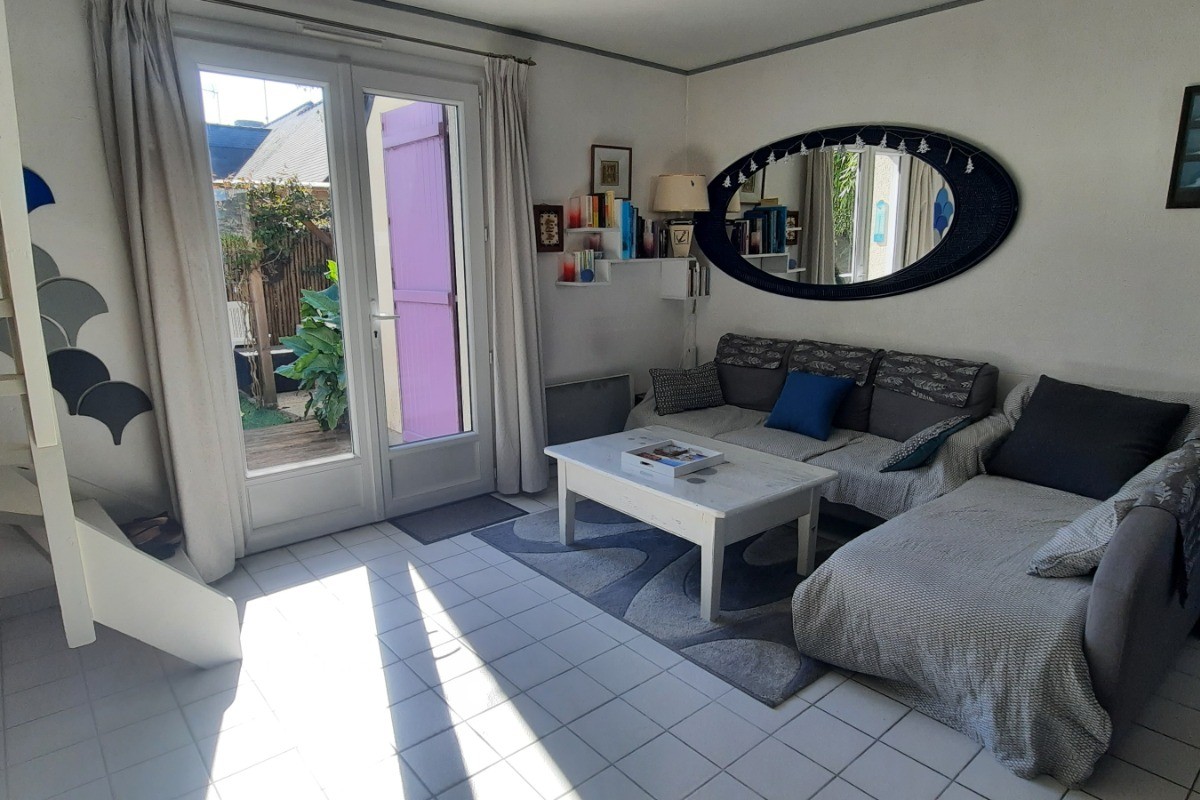 Coin salon et porte fenêtre donnant sur terrasse et jardin exposé Est