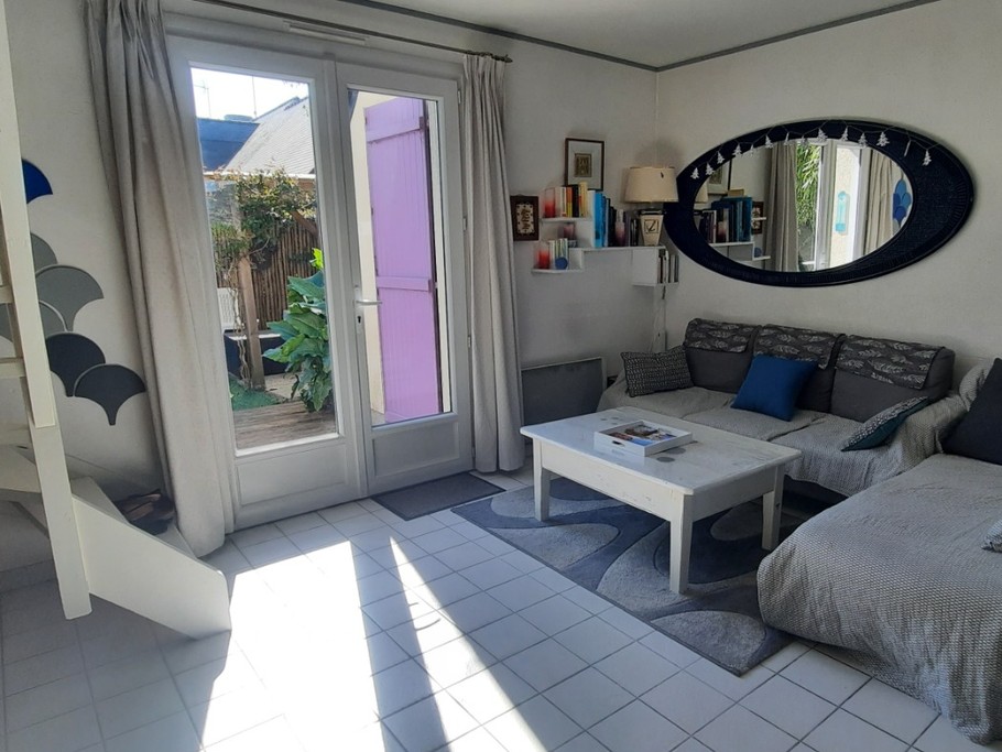 Coin salon et porte fenêtre donnant sur terrasse et jardin exposé Est