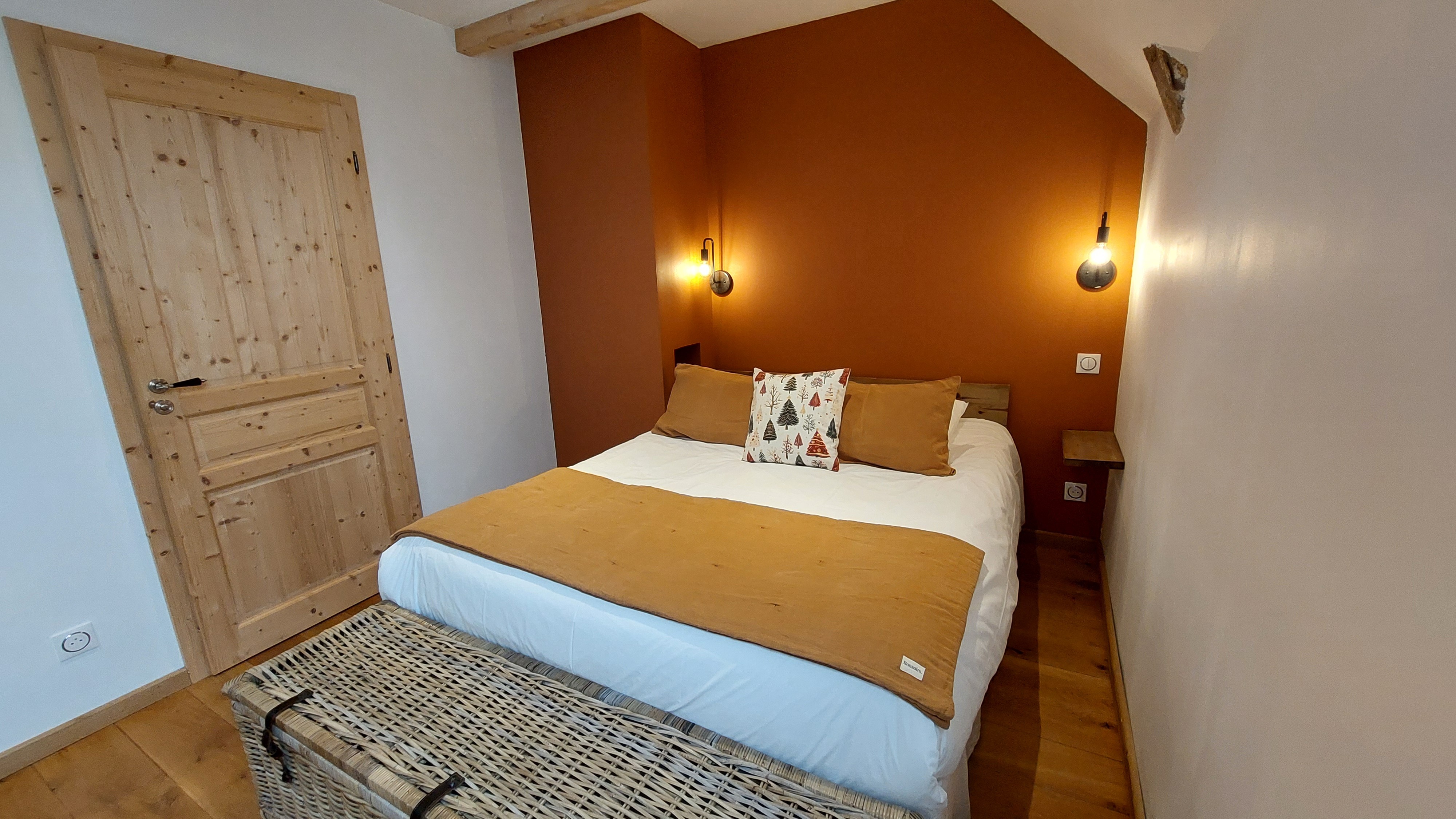 Cosy guest room with terracotta wall and double bed in Marchastel, Cantal