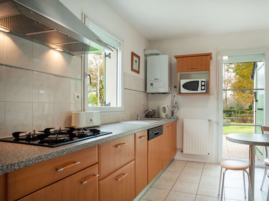cuisine sortie sur jardin et sa table extérieure sous store banne